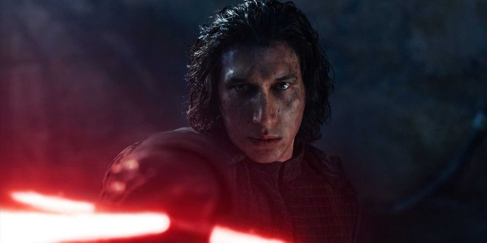 adam driver as kylo ren pointing his lightsaber at someone off-camera in star wars