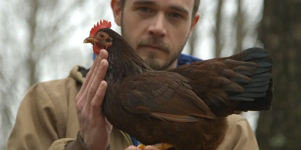 A man and his chicken in the doc "Chicken People."