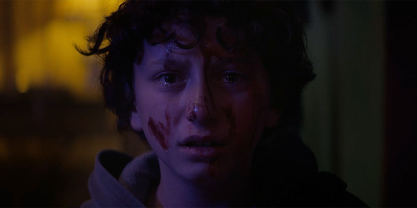August Maturo as Lucas, a child covered in blood looking at the camera, in Slapface