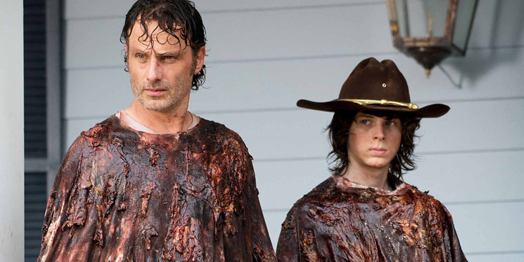 Rick and Carl Grimes standing side by side covered in walker blood and guts in The Walking Dead&rsquo;s No Way Out.