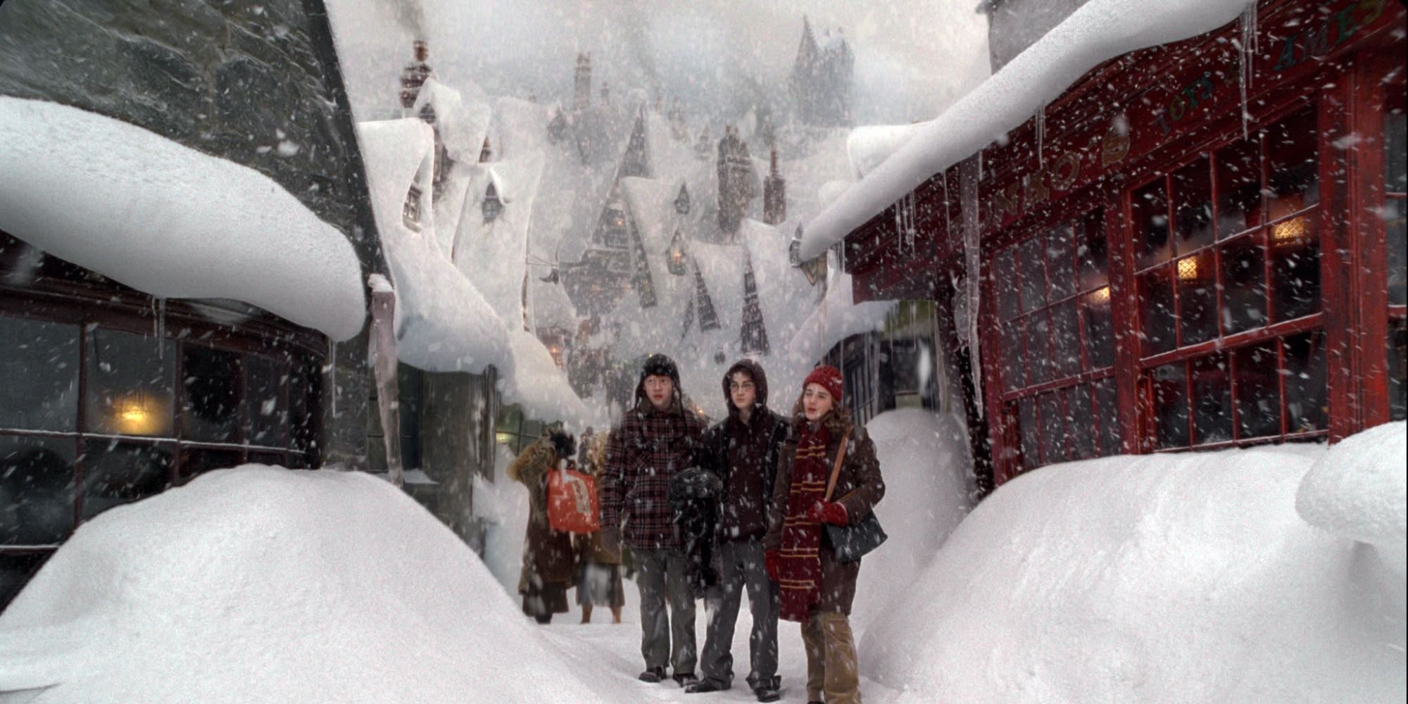 Harry, Ron, and Hermione in Hogsmeade covered by snow.
