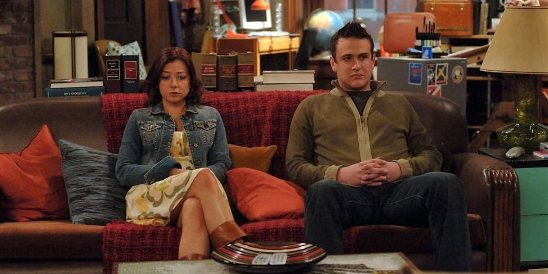 Alyson Hannigan and Jason-Segel sitting on a couch in How I Met Your Mother