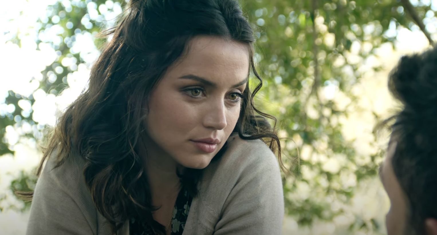 A close-up of Ana de Armas in front of the trees from the movie Deep Water.