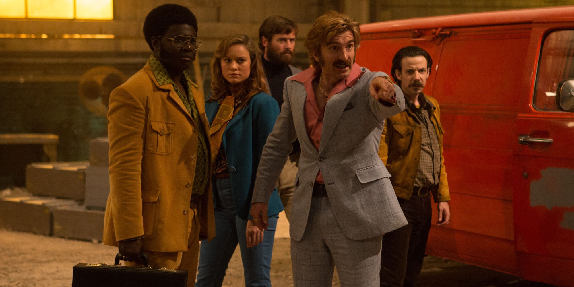 A group of well-dressed characters next to a van in a warehouse