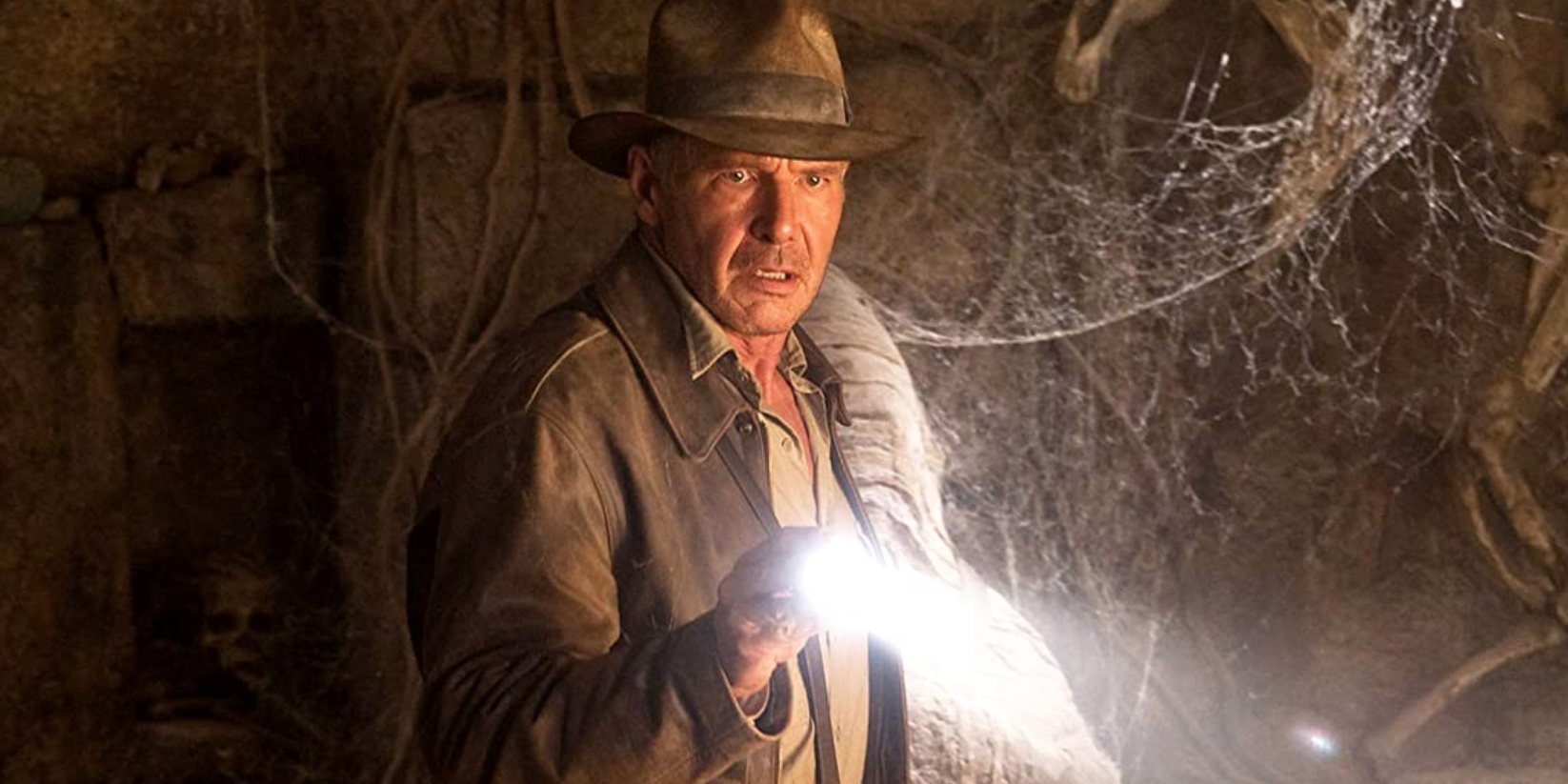 Indiana Jones pointe sa lampe de poche hors champ et a l'air surpris dans Indiana Jones et le Royaume du Crâne de Cristal.