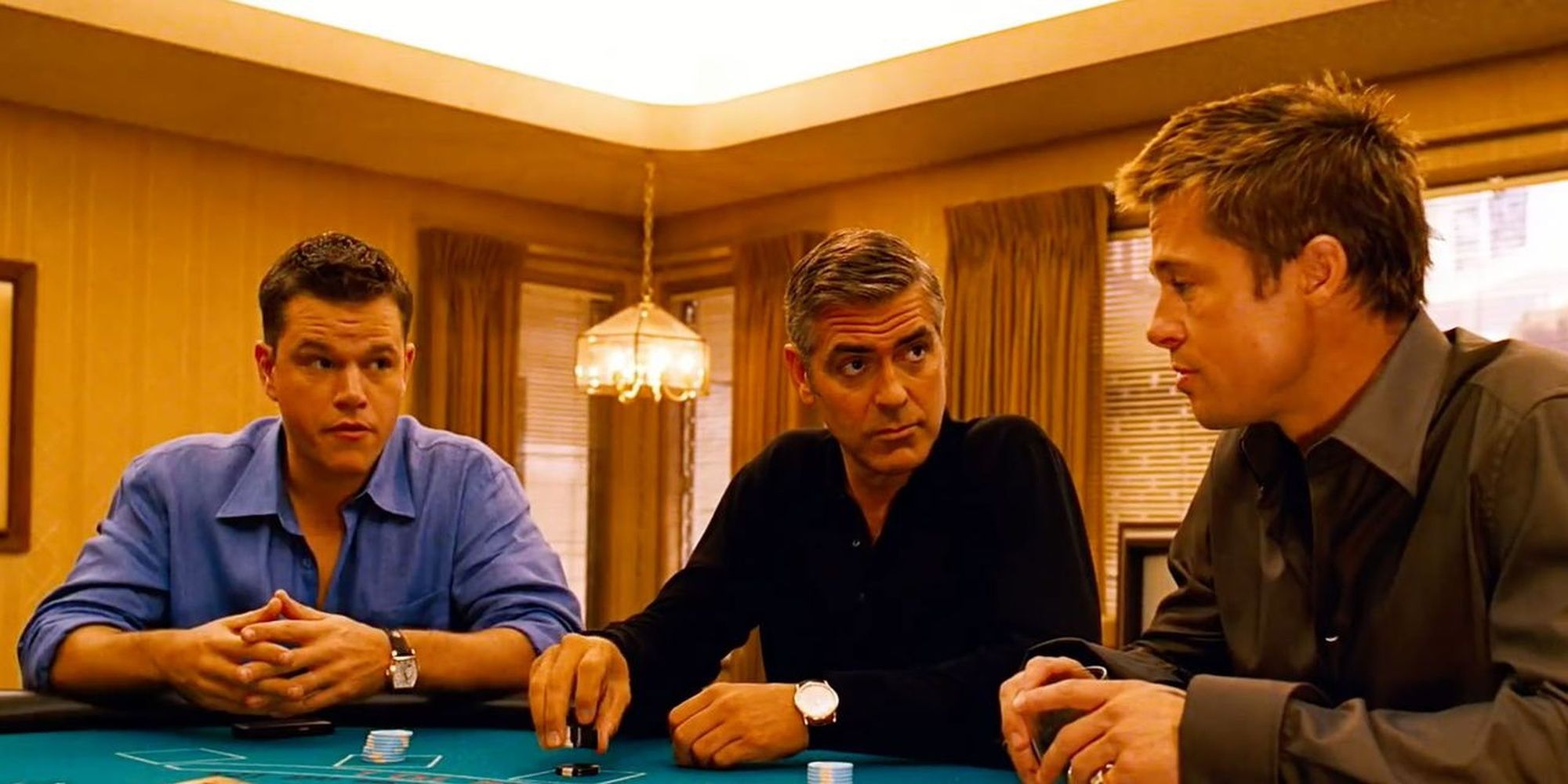 ​​​​​​​Linus (Matt Damon), Danny Ocean (George Clooney) and Rusty Ryan (Brad Pitt) sitting at a poker table in their room  Ocean's Eleven