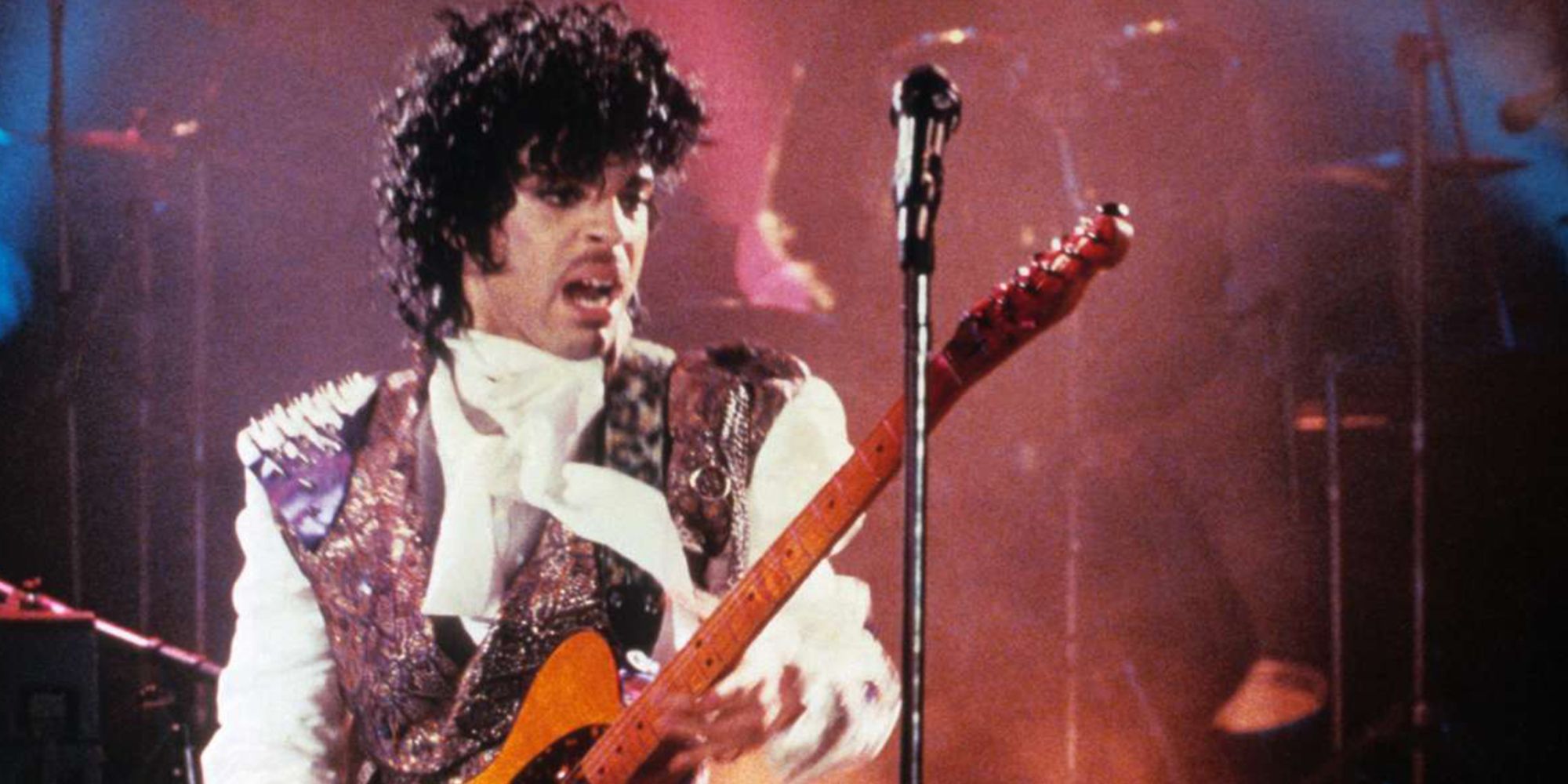 Prince playing a guitar onstage