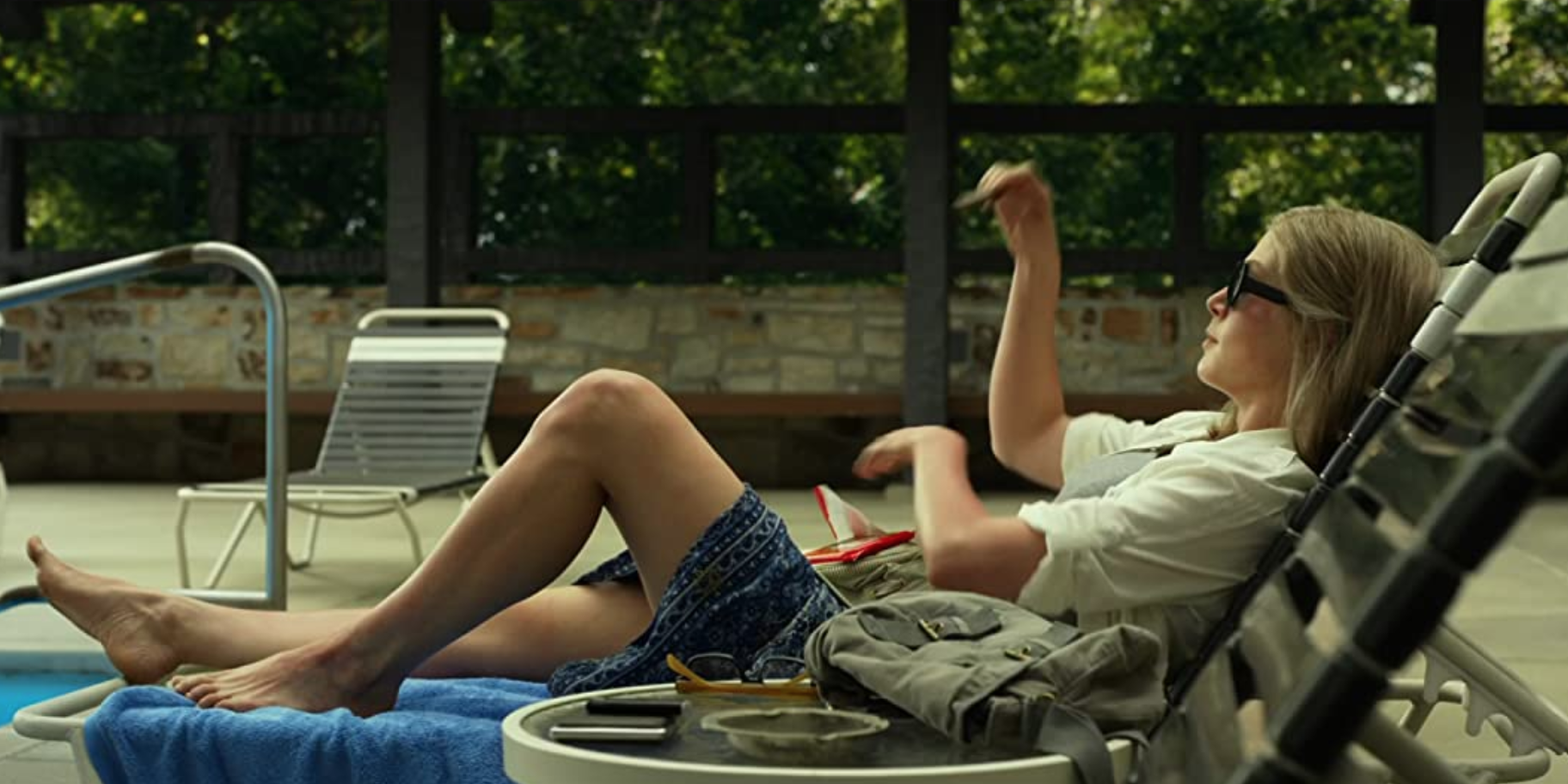 Rosamund Pike dans le rôle d'Amy Dunne assise sur une chaise de jardin dans Gone Girl