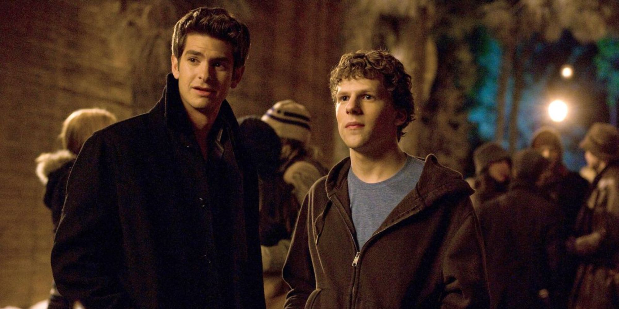 Eduardo Saverin (Andrew Garfield) standing next to Mark Zuckerberg (Jesse Eisenberg) on a college campus in The Social Network