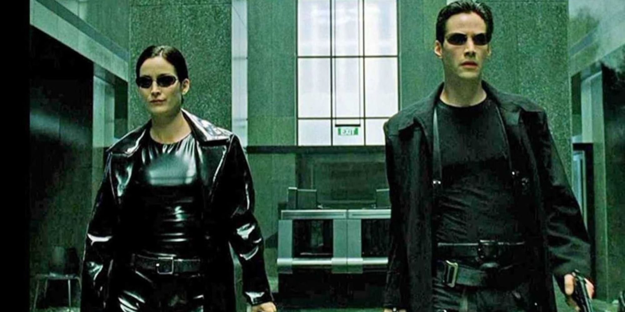 Keanu Reeves as Neo and Carrie-Ann Moss as Trinity walking in The Matrix.