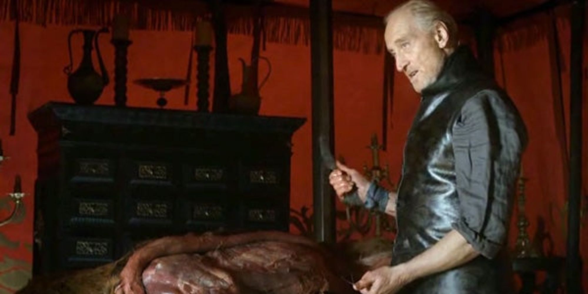 Charles Dance como Tywin Lannister esfolando um cervo em Game of Thrones.