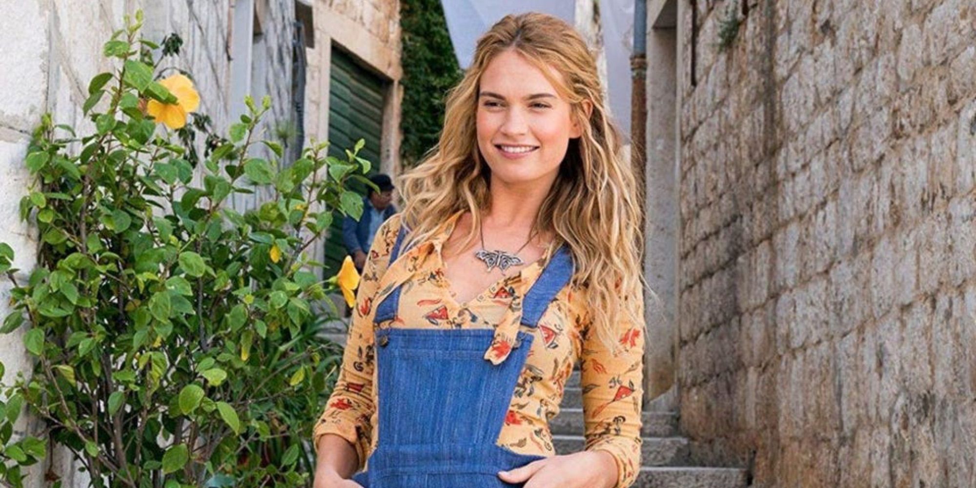 Lily James as Young Donna, wearing her overalls and smiling in Mamma Mia! Here We Go Again