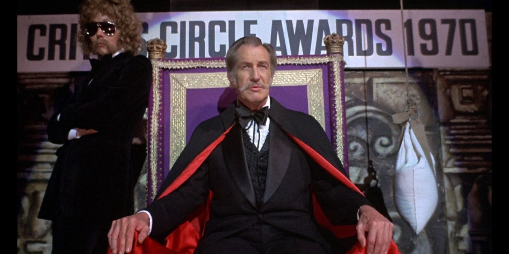 Edward Lionheart sitting down on a chair on the stage in Theatre of Blood