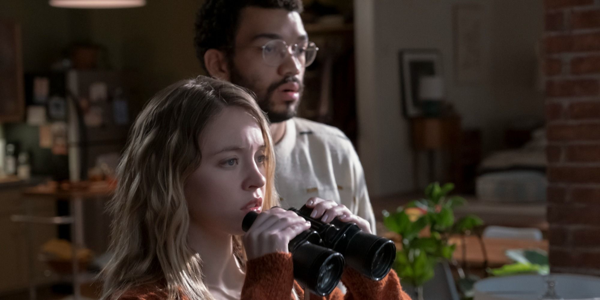 Sydney Sweeney and Justice Smith spying their neighbours with binoculars in The Voyeurs