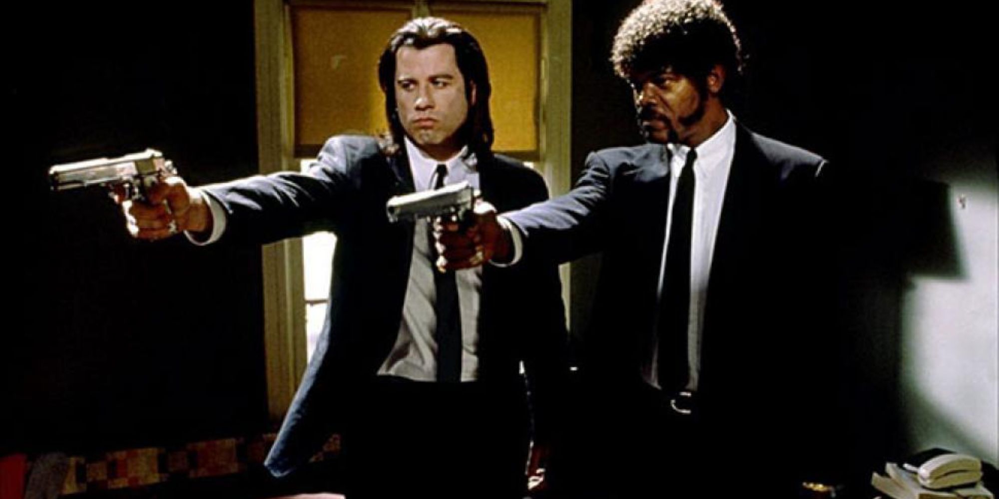 Deux hommes qui lèvent leurs armes dans Pulp Fiction.
