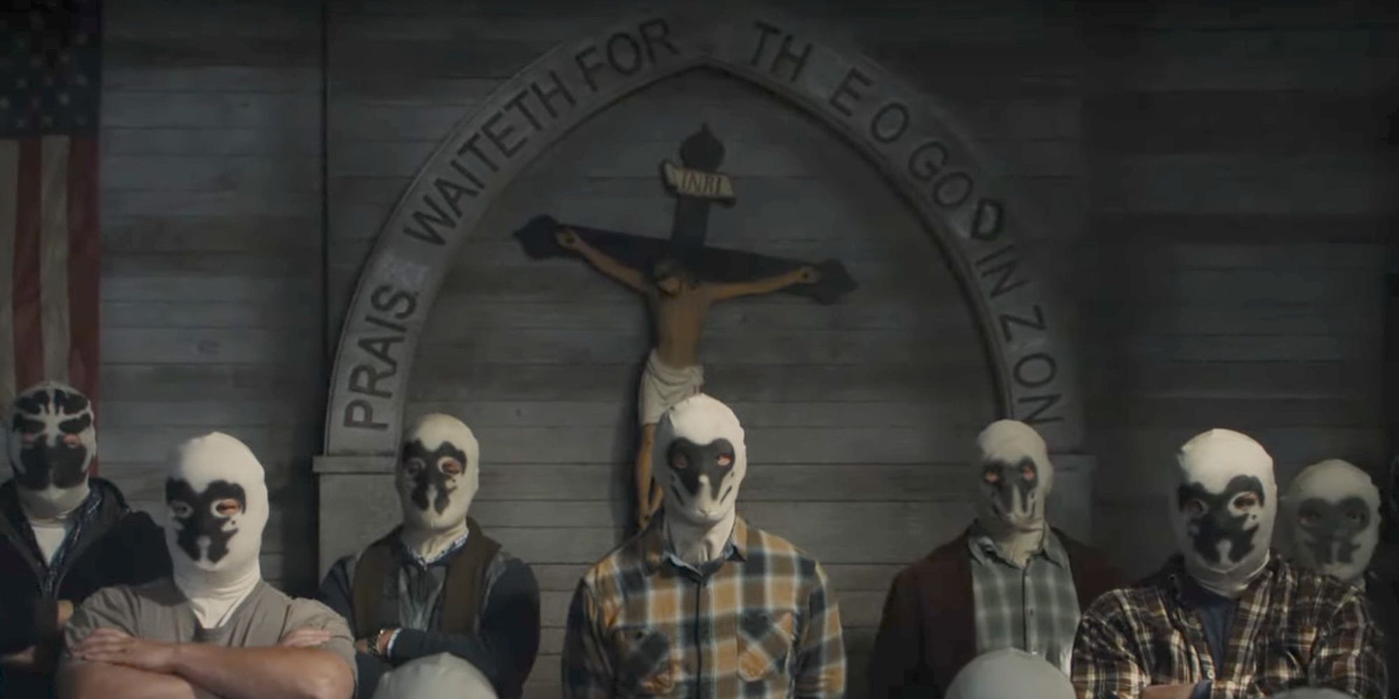 A group of men wearing white masks standing in line under a large cross in Watchmen