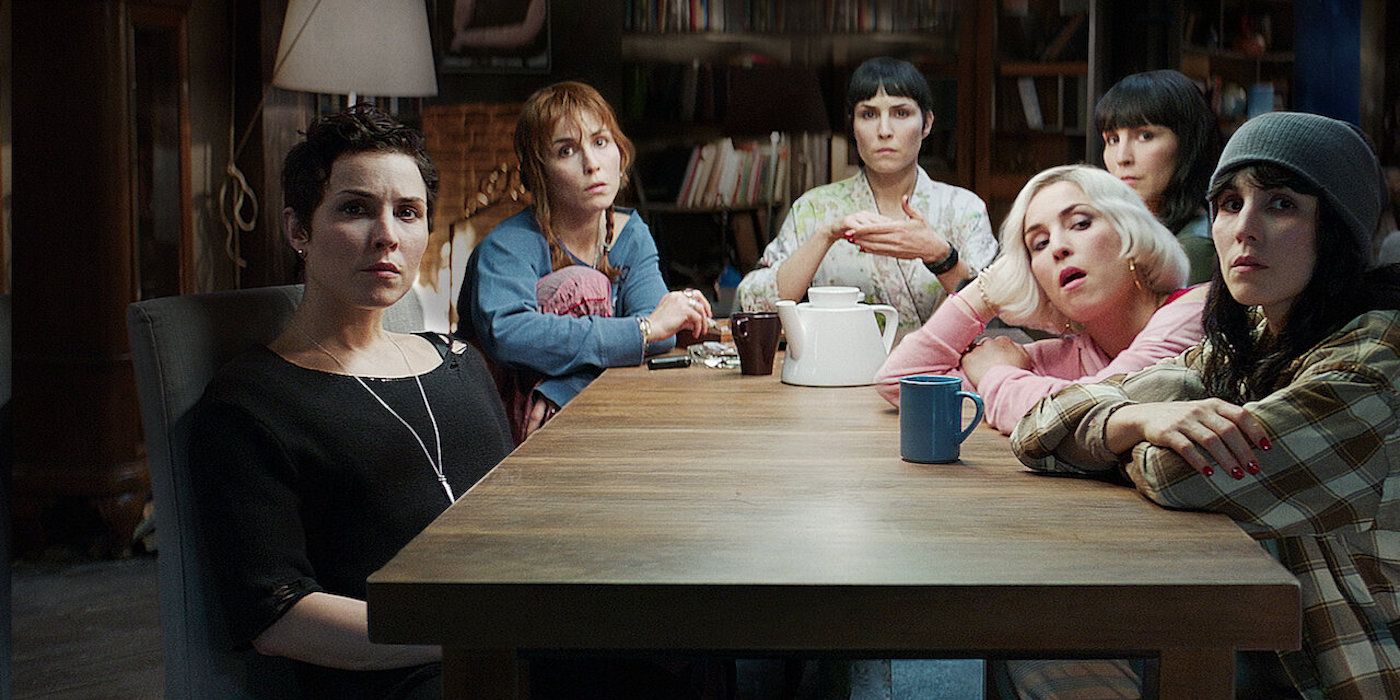 Noomi Rapace as the Settman siblings sitting at a table in What Happened to Monday