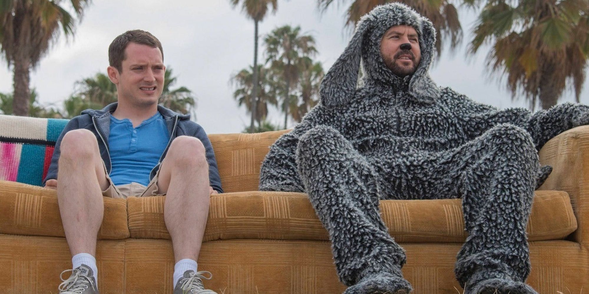 Wilfred (Jason Gann) and Ryan (Elijah Wood) sitting on their couch outside in Wilfred