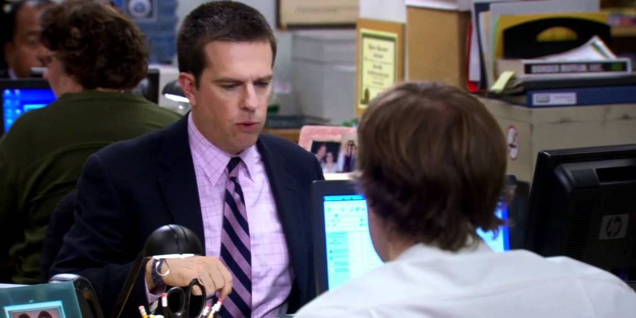 The Office: Andy Bernard is seated at his desk, opposite Jim Halpert, and looking for his cellphone.