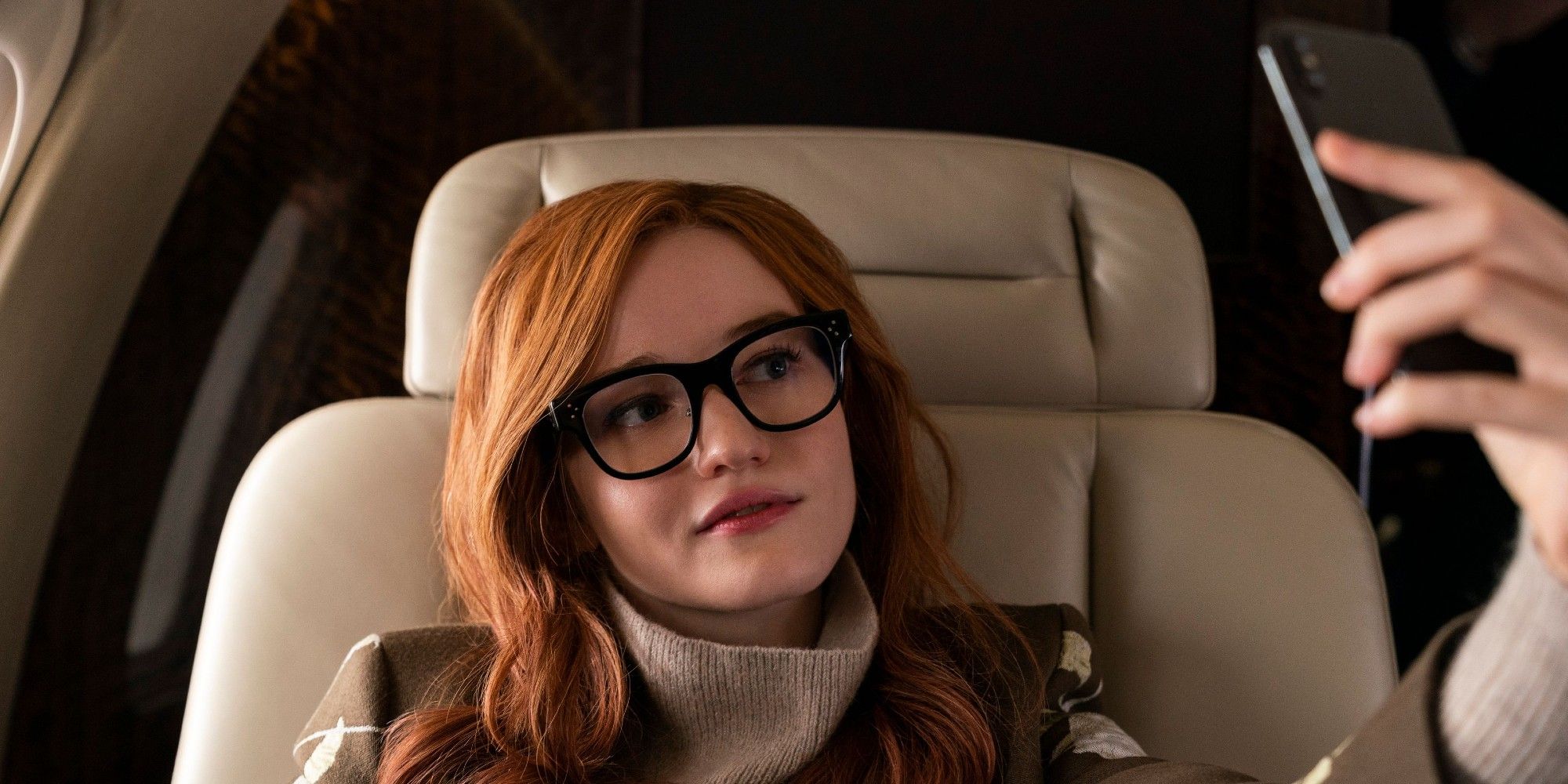Julia Garner as Anna Delvey takes a selfie while on a plane