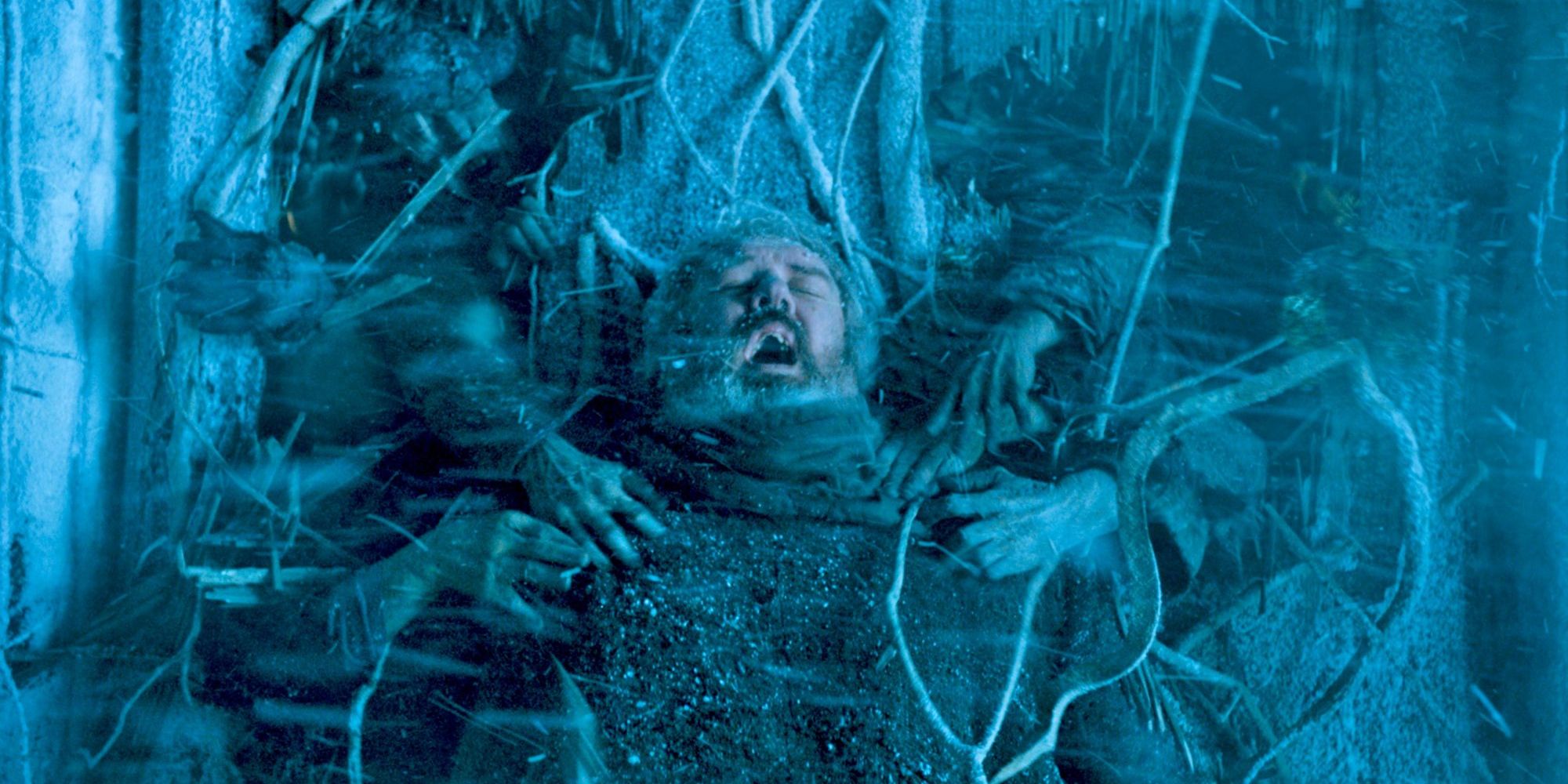 Hodor bloqueando una pared mientras las manos de un wight se aferran a él en Game of Thrones.