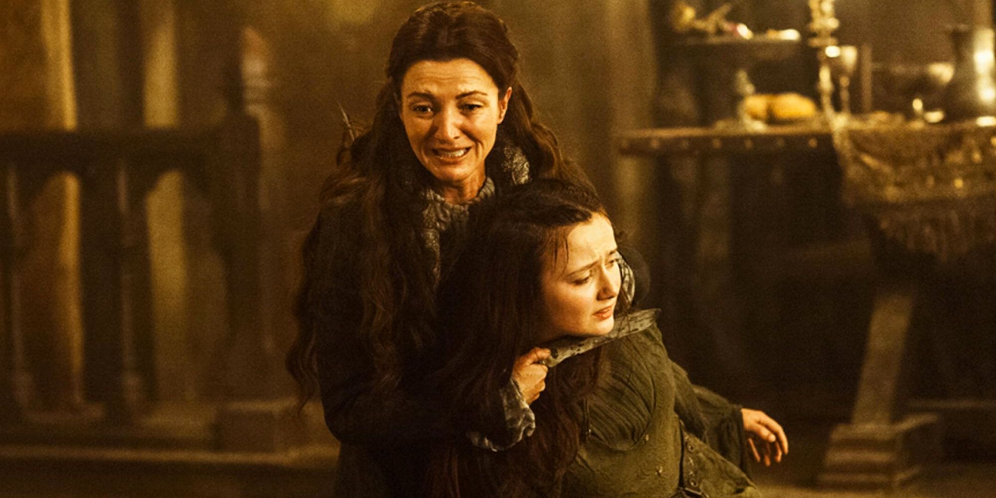 Michelle Fairley as Catelyn Stark crying and holding Frey's wife as hostage in Game of Thrones Rains of Castamere, the red wedding episode