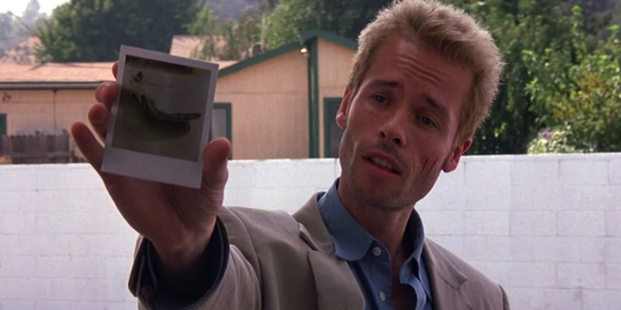 Guy Pearce holding a photograph in Memento