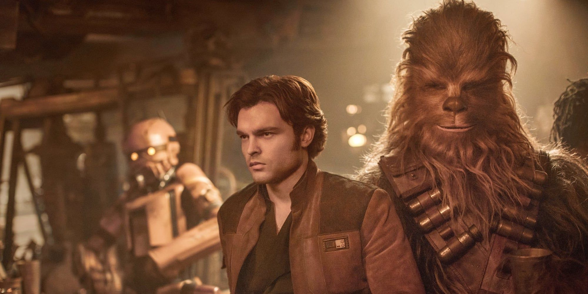 close-uup Alden Ehrenreich as Han Solo and Chewbacca in Solo: A Star Wars Story with a droid in the background