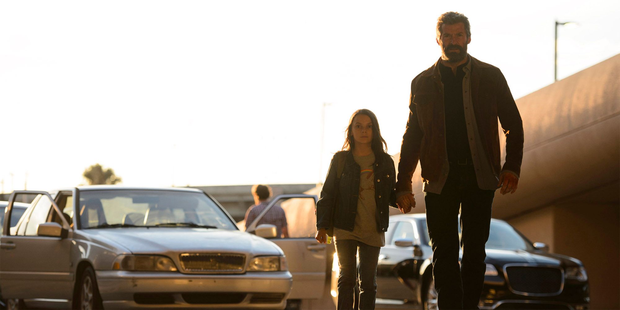 Dafne Keen as Laura and Hugh Jackman as Logan Holding Hands and Walking in 2017's Logan
