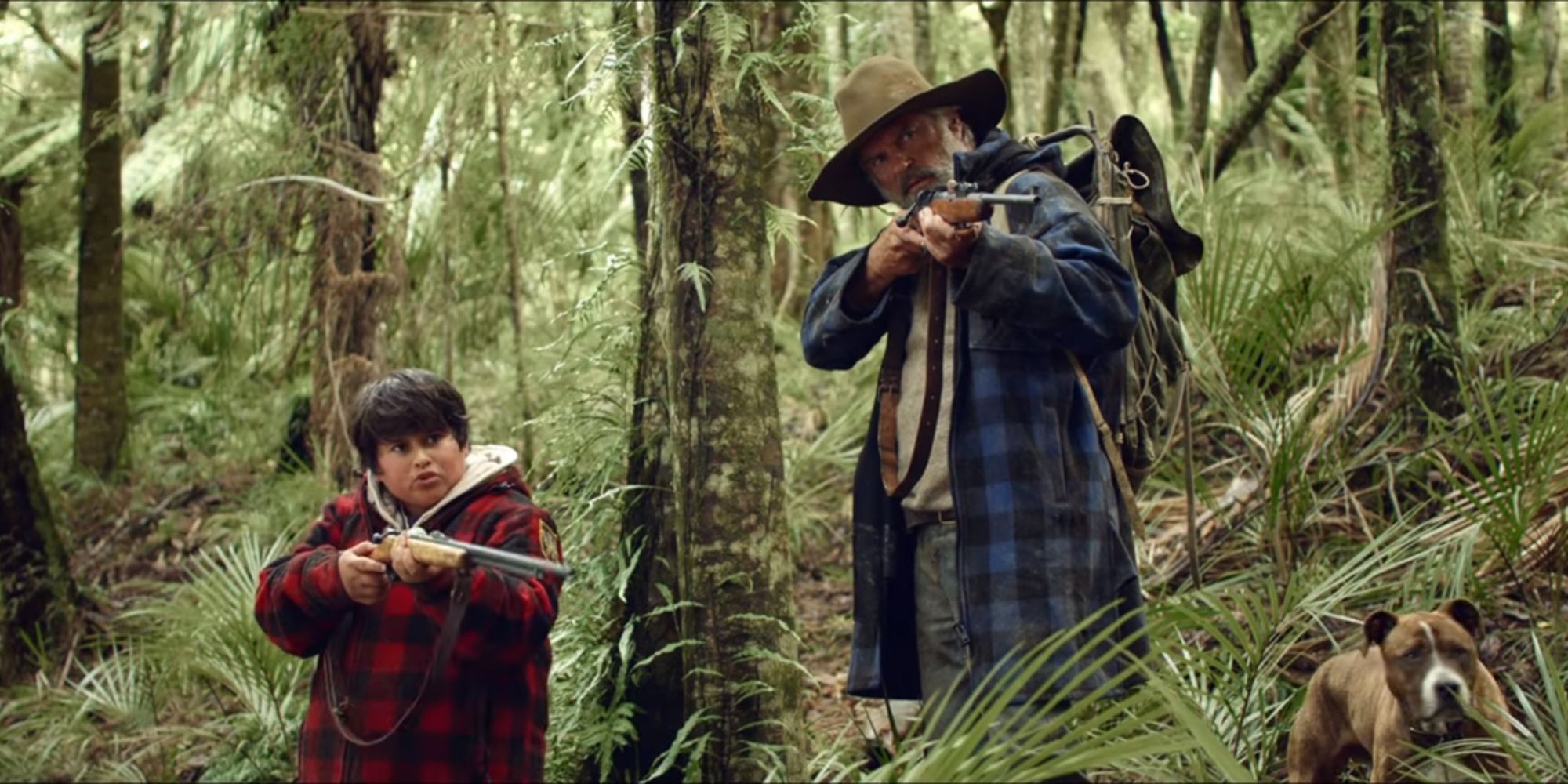 Hector and Ricky aiming their rifles in the same direction in Hunt for the Wilderpeople.