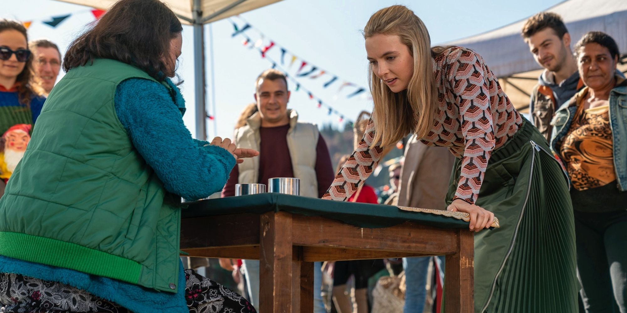 Villanelle (Jodie Comer) plays a carnival game at the Harvest Festival;