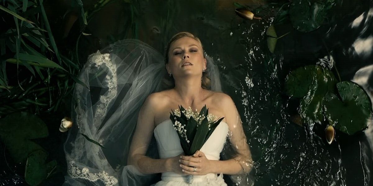 Justine en robe de mariée allongée sur un lit d'eau dans Melancholia (2011) 
