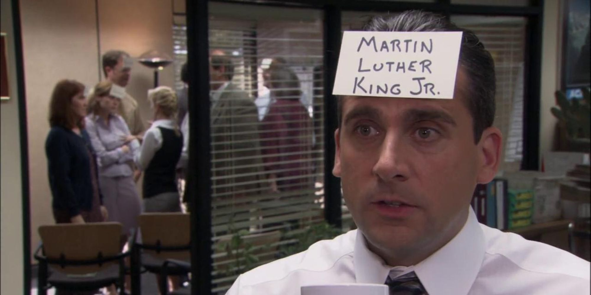 Steve Carell as Michael Scott with an index card on his head reading "Martin Luther King Jr." on The Office