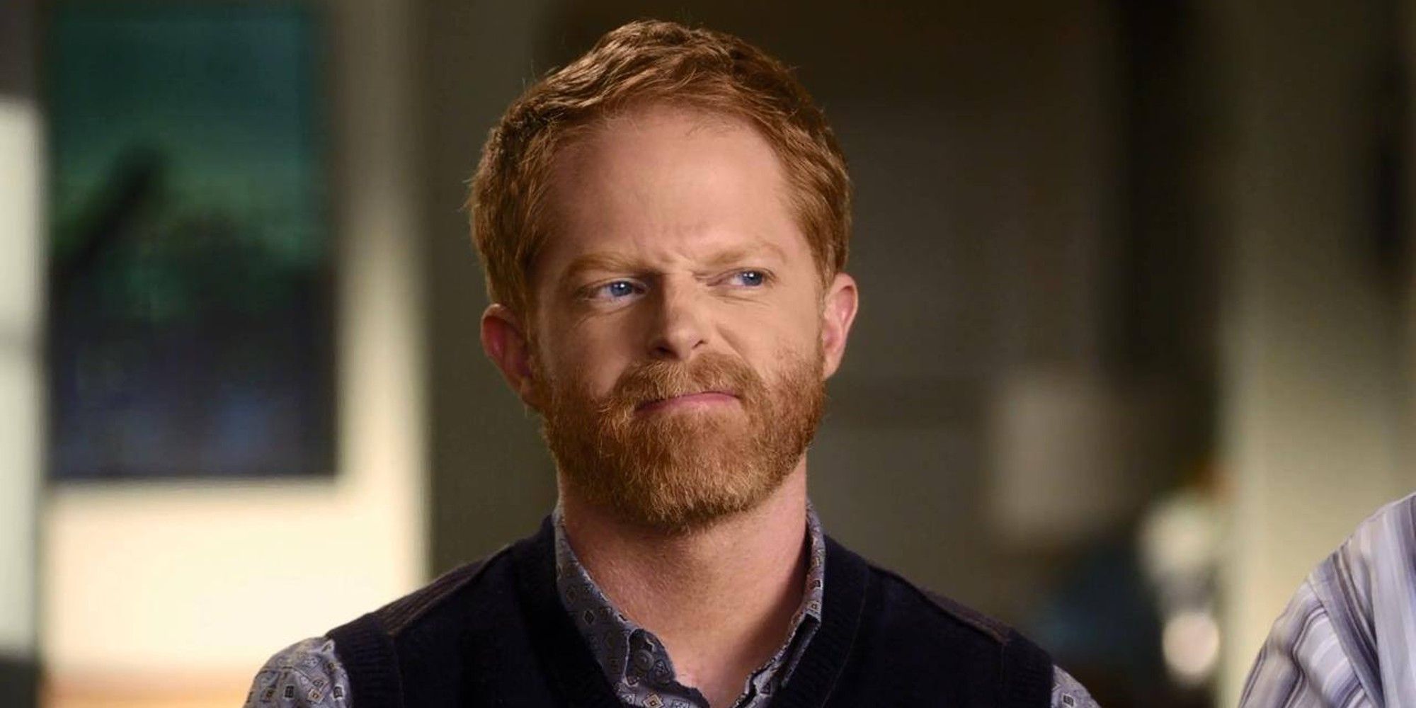 Jesse Tyler Ferguson as Mitchell Pritchett cringing while talking to the camera in Modern Family.