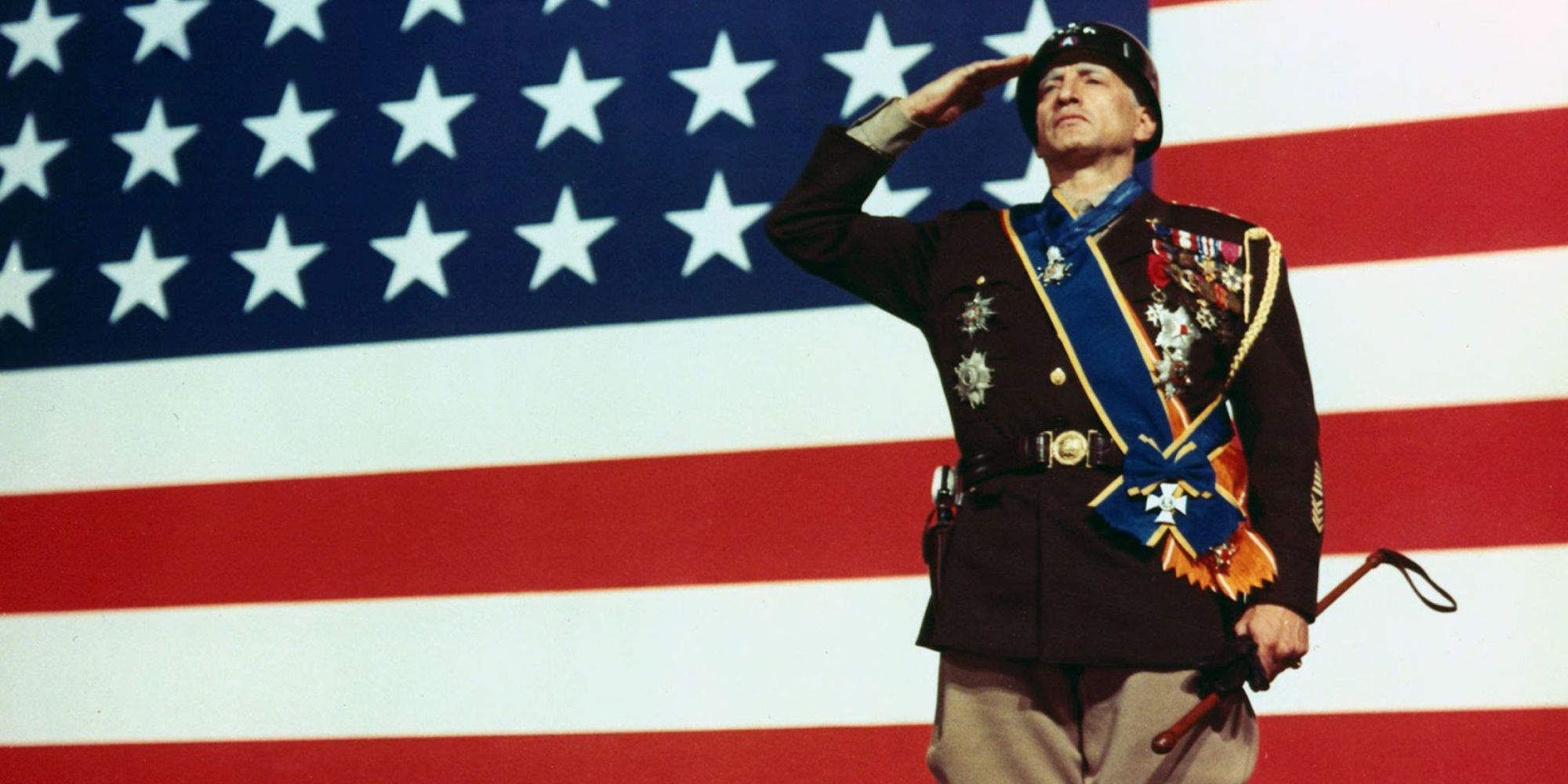 George S. Patton saluting in front of an American flag in Patton