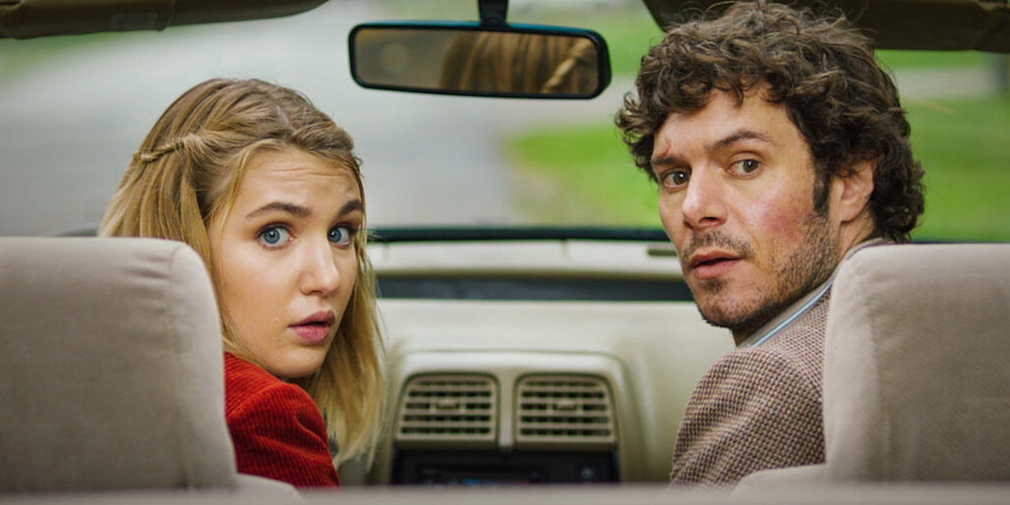 Sophie Nélisse and Adam Brody sitting in a car in &lsquo;The Kid Detective&rsquo;