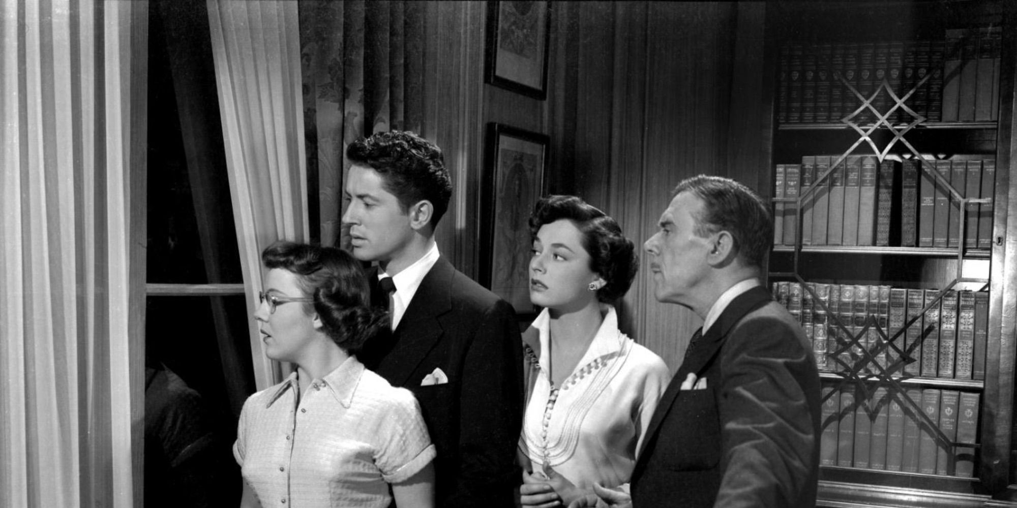 The ensemble cast of Strangers on a Train looking out the window of an apartment