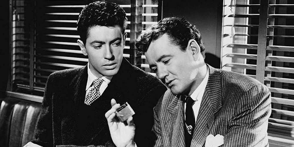 Robert Walker and Farley Granger sitting next to each other talking in Strangers on a Train