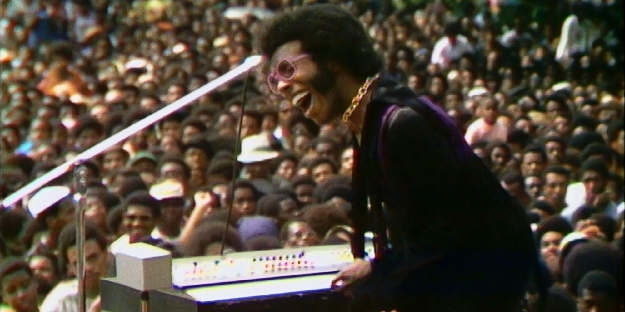 A man performing on stage before a large crowd in Summer of Soul