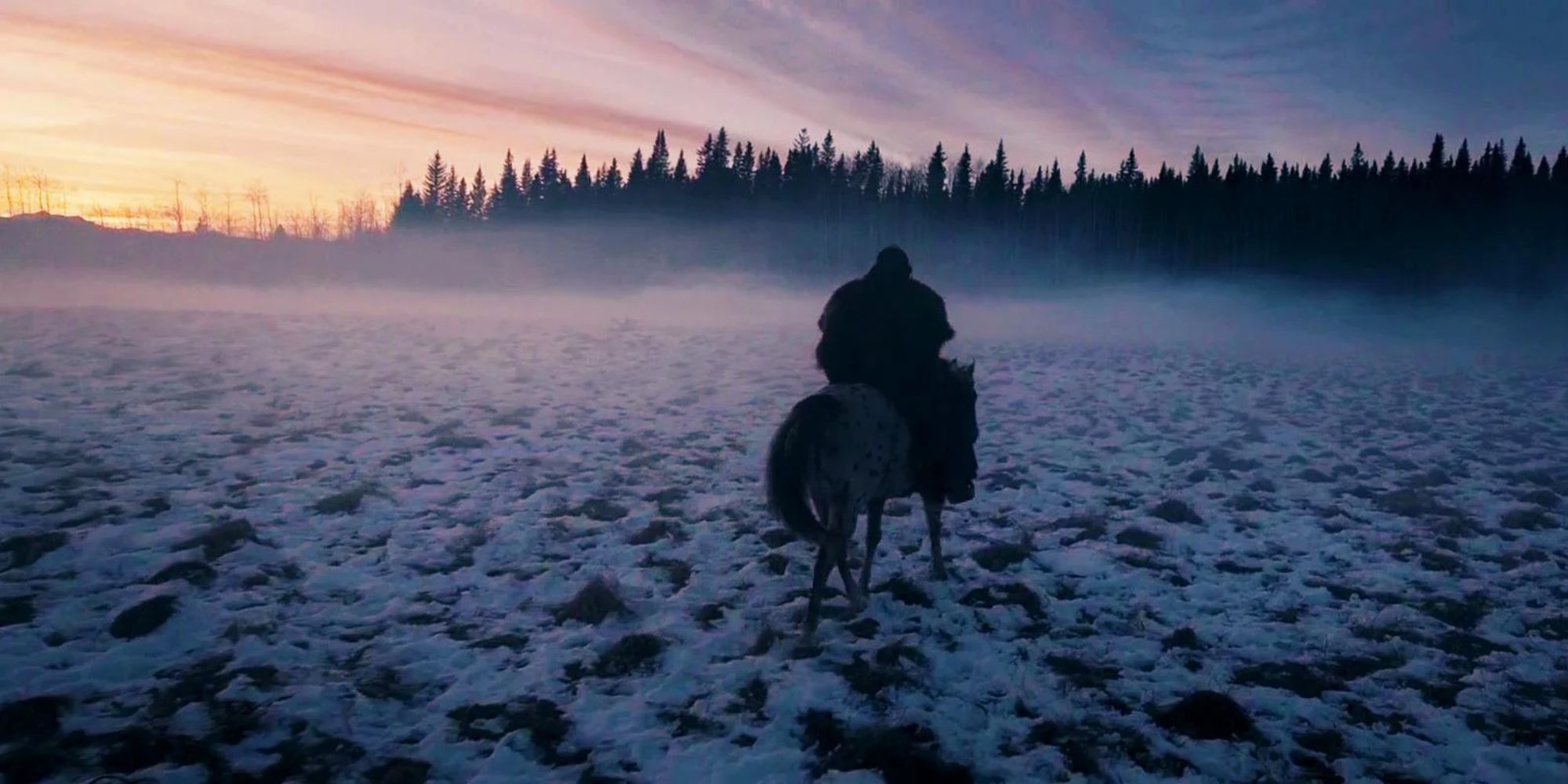 A man on a horse traversing a snowy field in The Revenant