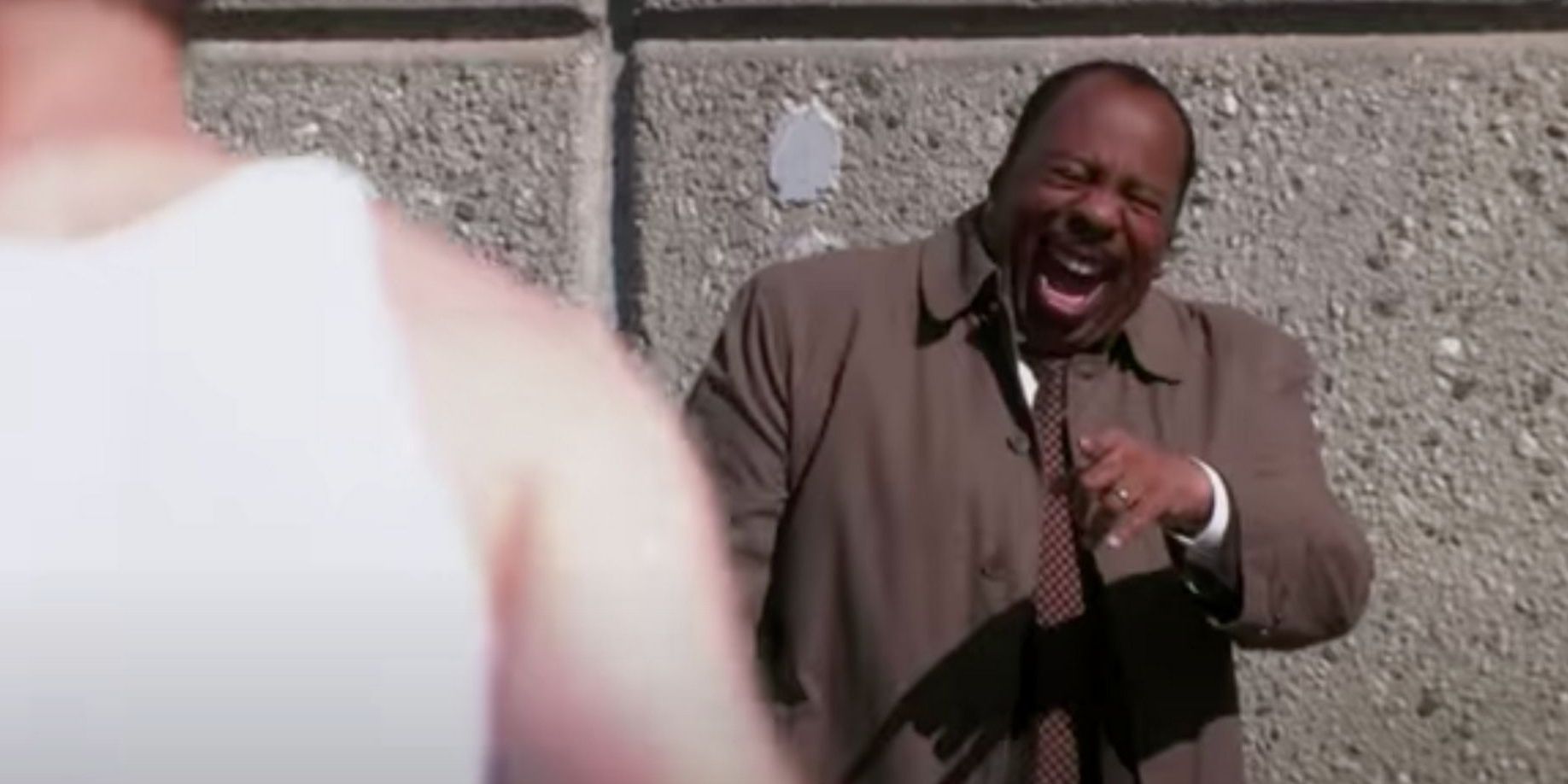 The Office: Stanley is pointing and laughing at Dwight Schrute who has had his velcro suit torn off.