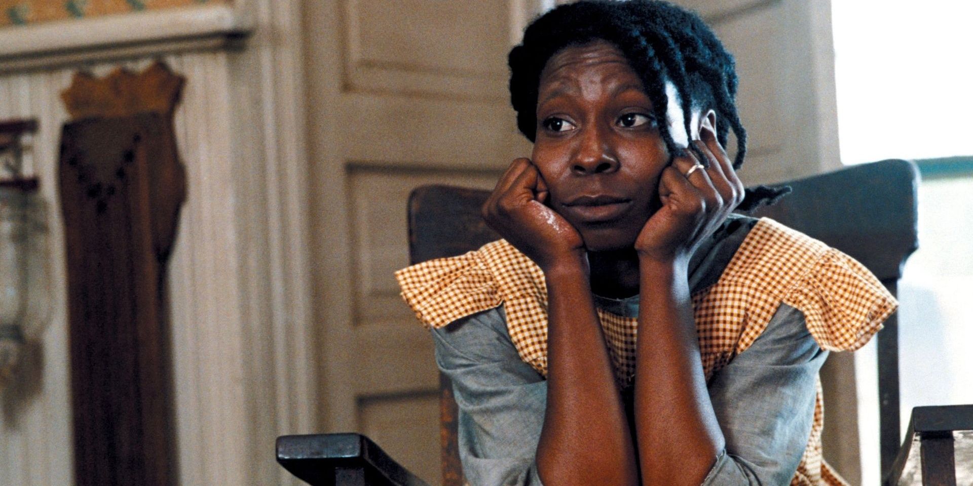 Celie with her chin on her hands looking to the distance in the Color Purple