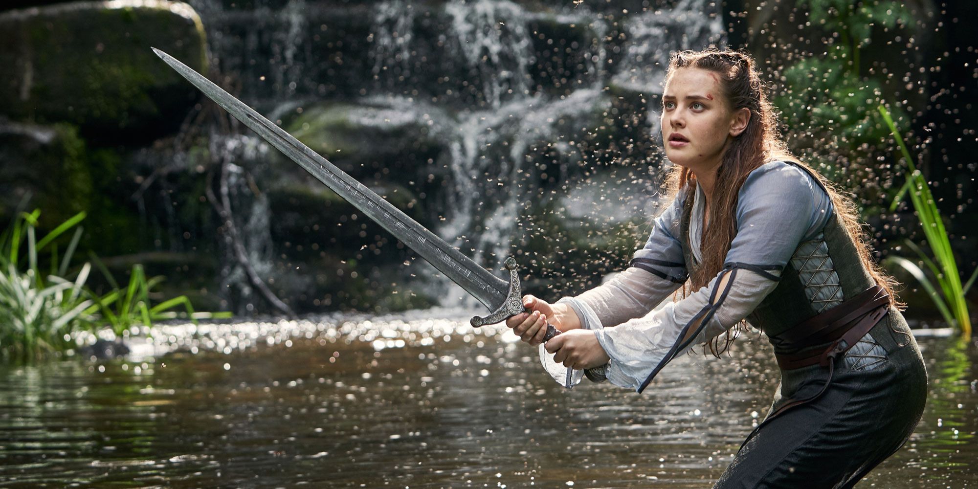 Still of Nimue wielding a sword in a lake (Netflix 2021)