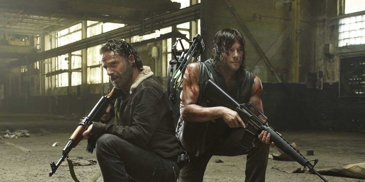 Daryl and Rick crouched in a building with weapons