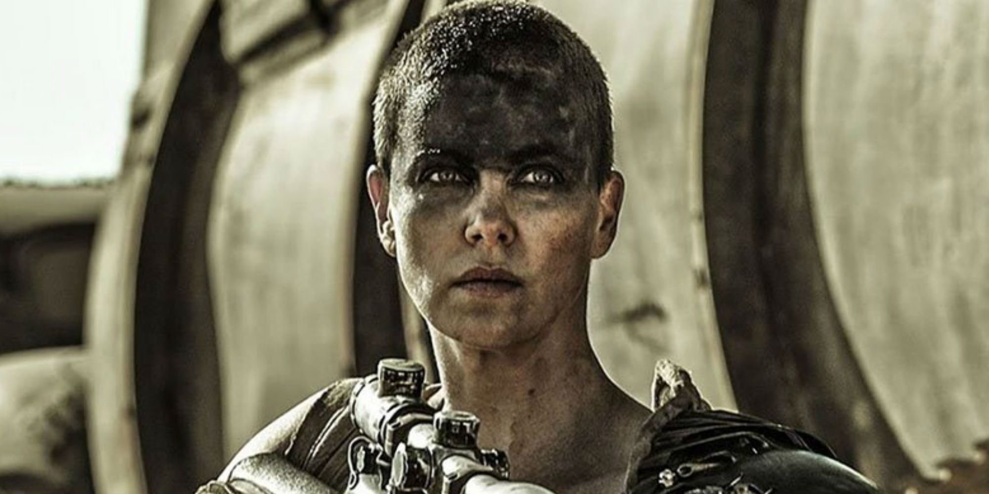 Imperator Furiosa with her gun looking intently in Mad Max: Fury Road.