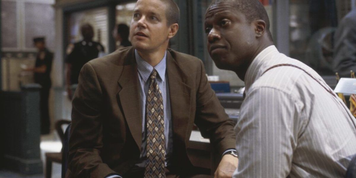 Two men in suits in a police station look up in a scene from Homicide: Life on the Street.