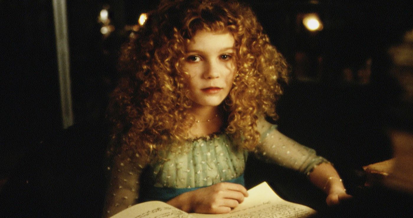 Kirsten Dunst looks at the camera while flipping through a book in ``Interview with the Vampire.''