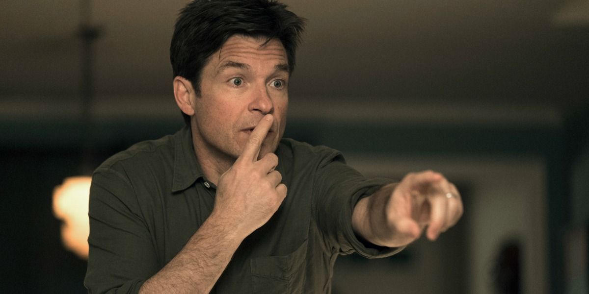 Jason Bateman as Max doing the hush sign and pointing at someone off-camera in Game Night