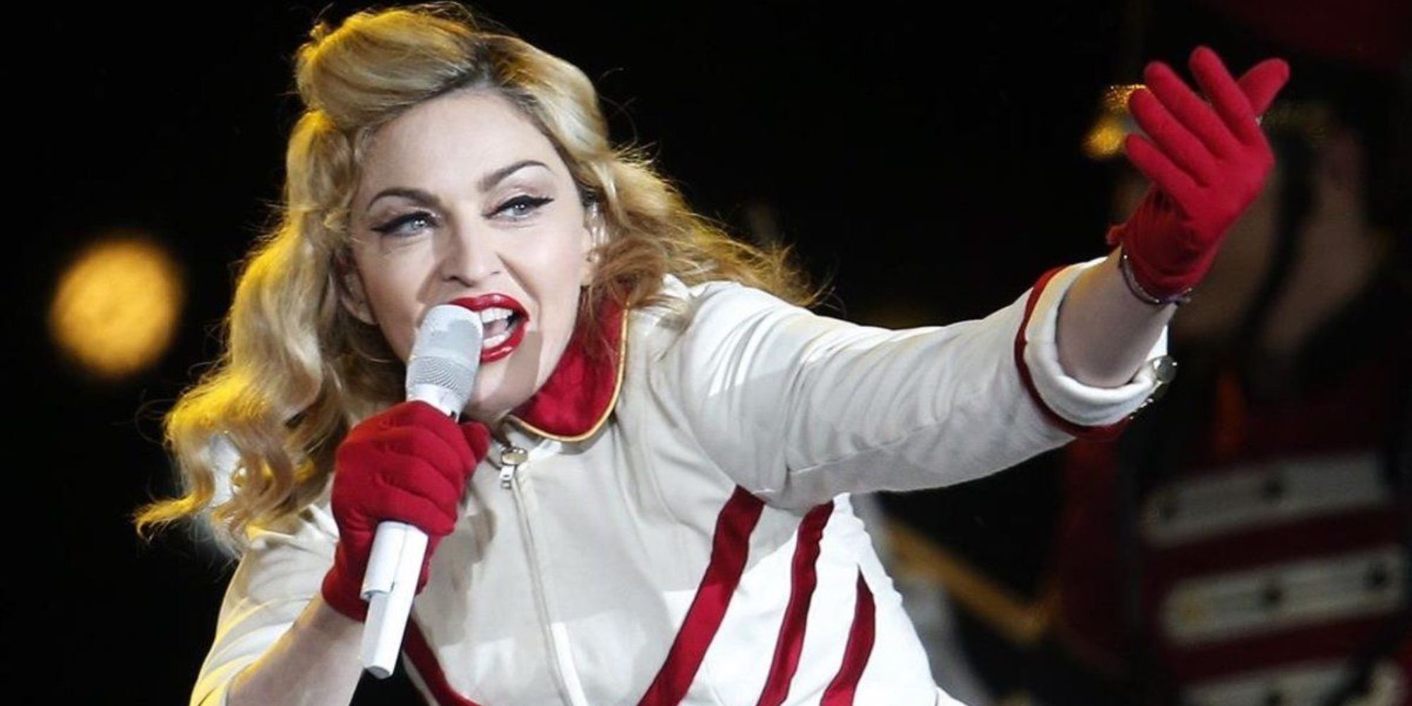 madonna singing onstage in white and red outfit