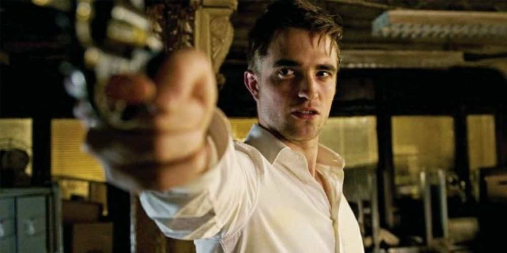 Eric aiming his gun at someone off-camera in Cosmopolis.